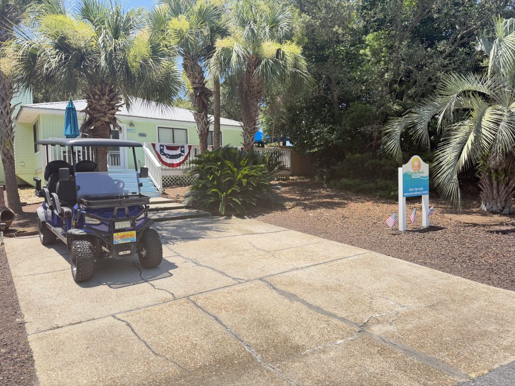 Blue golf cart parked in the driveway of Barefoot Paradise vacation rental in Panama City Beach, Florida
